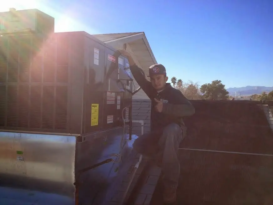 HVAC technician performing AC Tune-Up on a rooftop unit in West Boylston